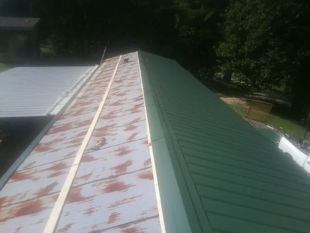 Old rusted panels beside newly installed green metal roofing — Wind Damage Roof Repair by Roofing Brothers in Redding