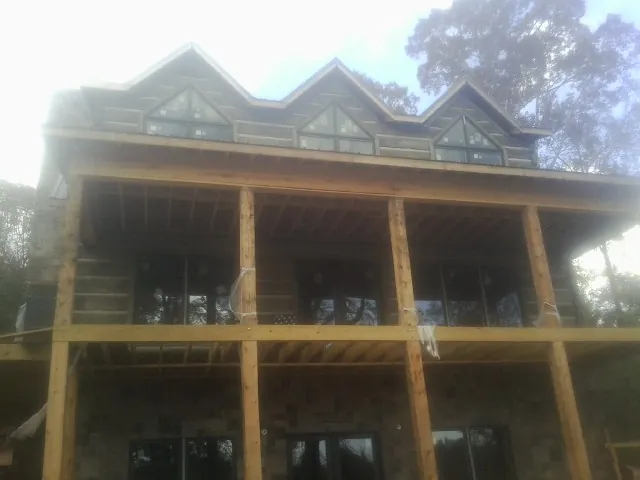 Dormers and porch framing on a large log home under construction — Roof Coating work by our crew in Redding