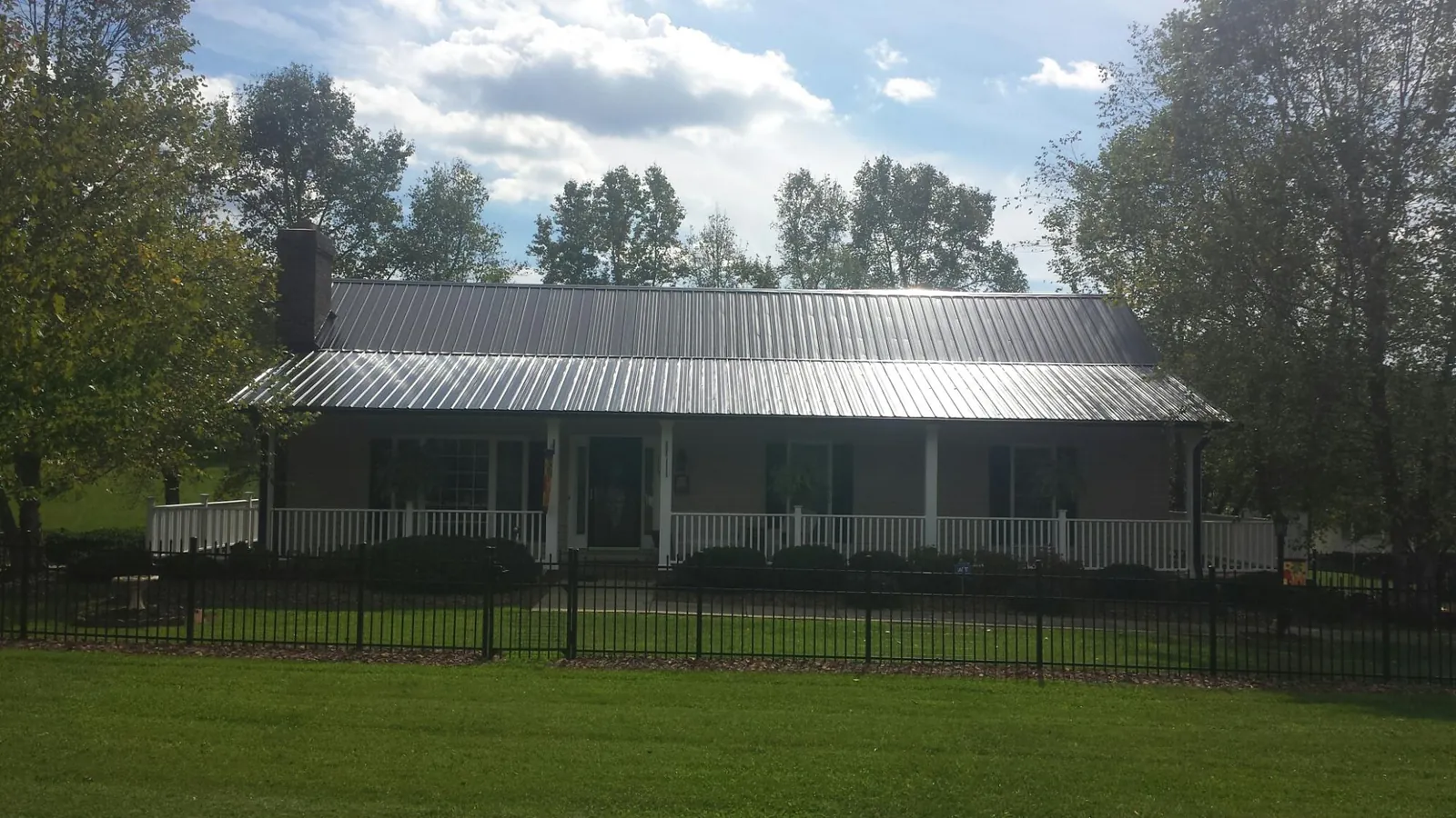 Gray metal roof on a brick ranch with a full width front porch — Gutter Guard Installation work by our crew in Redding
